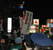 デモ到着地の新宿駅東口広場で「反・貧困」の旗を振る参加者たち